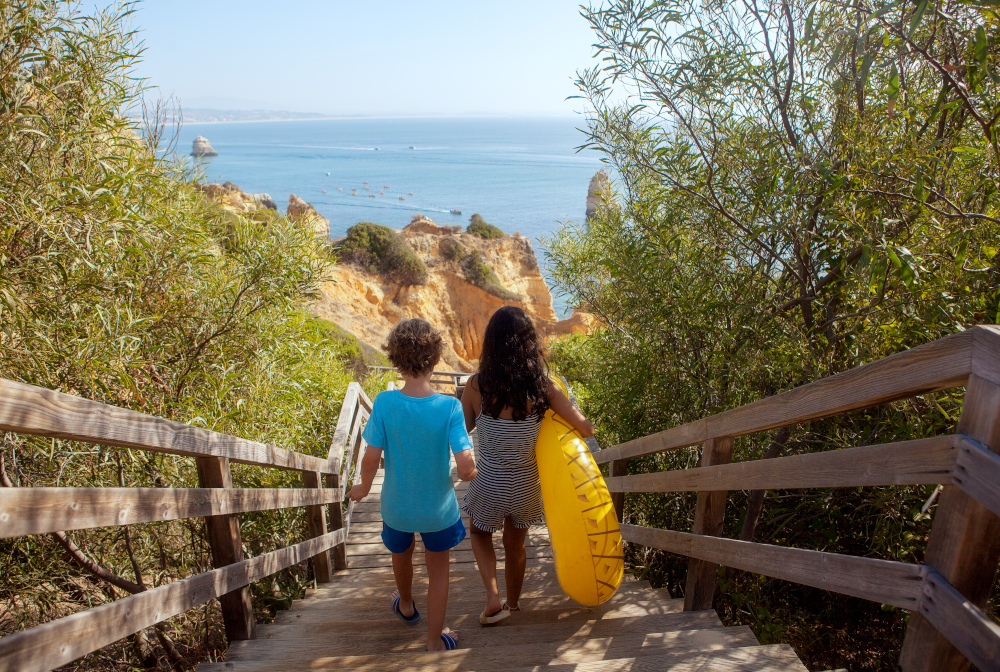 Two Kids Walking Down To Beach.rear View