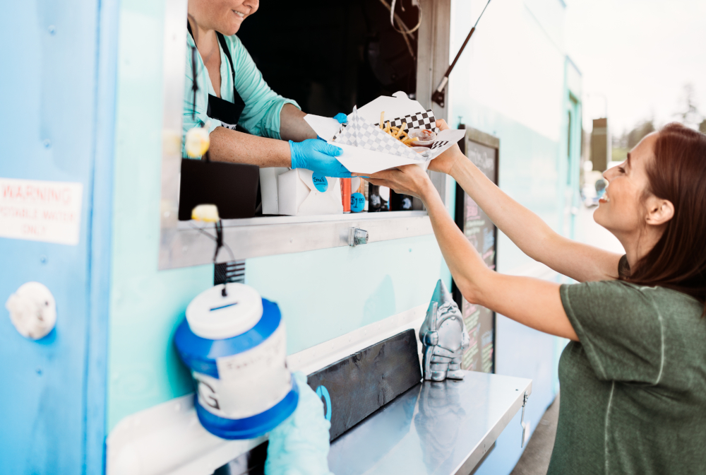 Woman Receiving Order At Food Truck