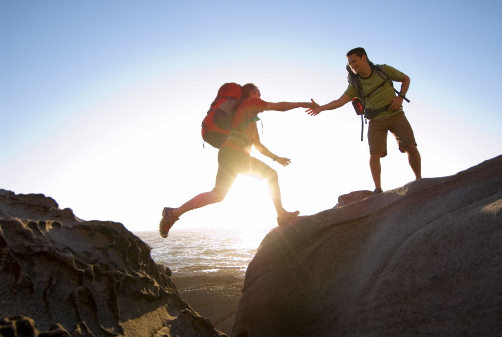 Hikers Jump On Rocky Pacific Coast.