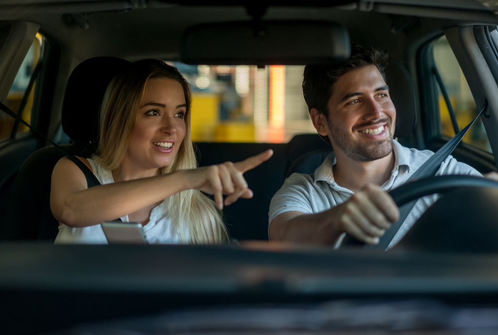 Couple Driving And Using A Gps While Pointing Their Way