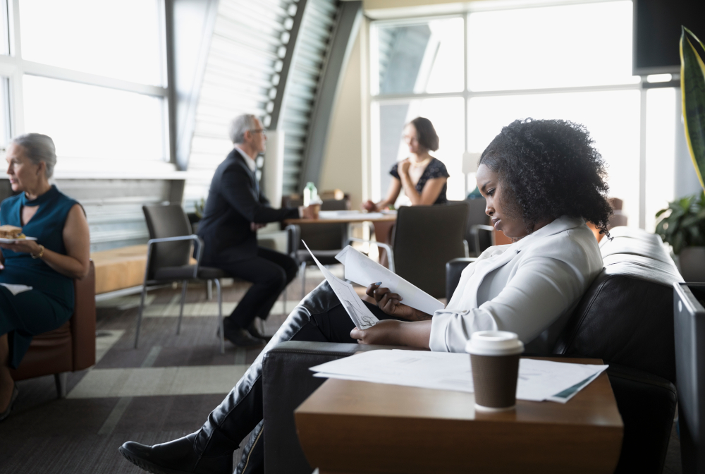 Focused Businesswoman Reviewing Paperwork In Business Lounge