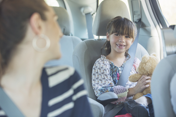 Mother Turning And Smiling At Daughter In Back Seat Of Car