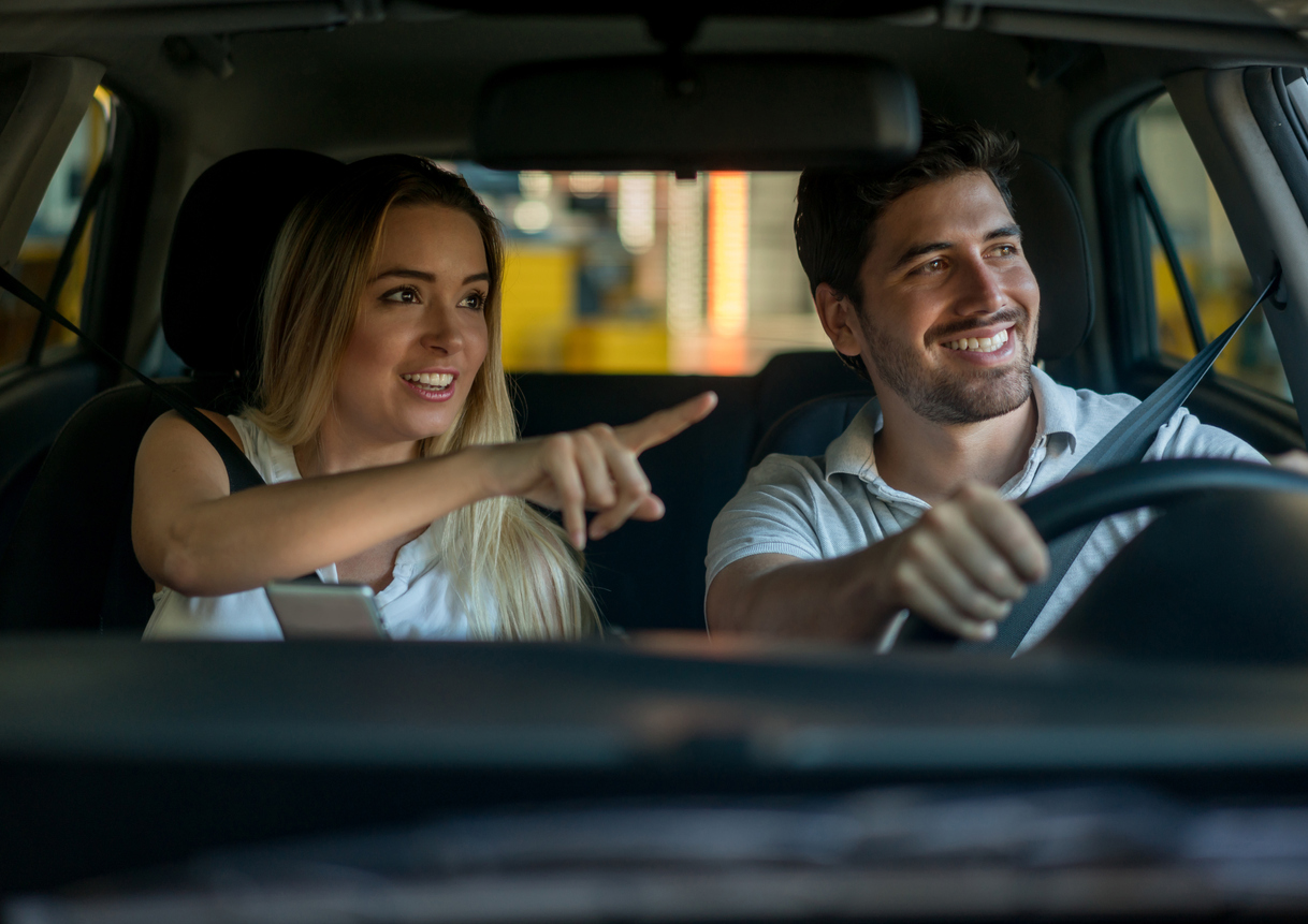 Couple Driving And Using A Gps While Pointing Their Way