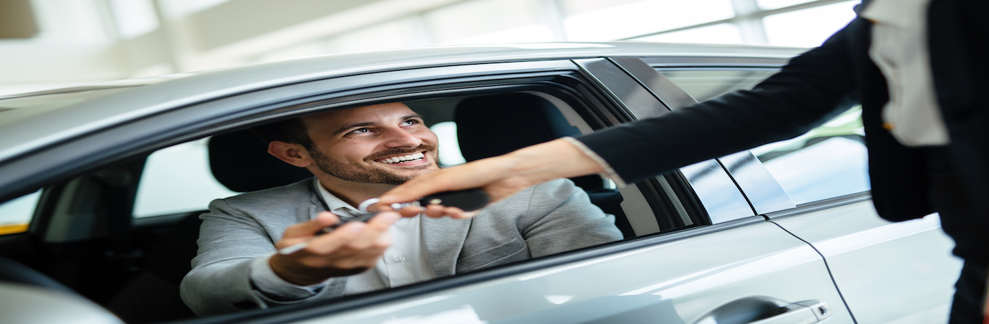 Professional Salesperson During Work With Customer At Car Dealership.