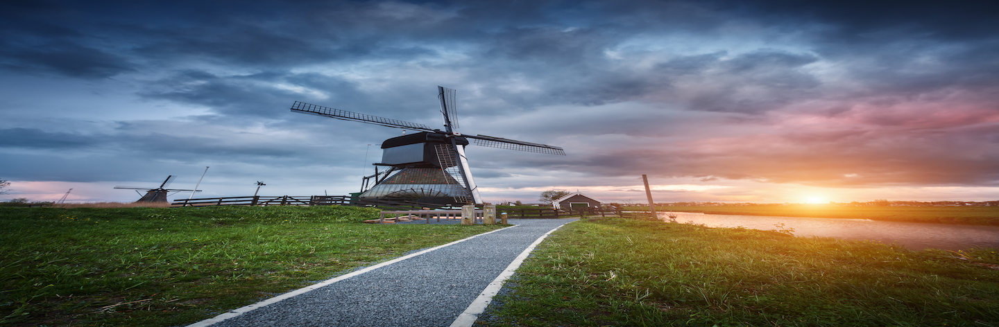 Landscape With Traditional Dutch Windmills At Sunset