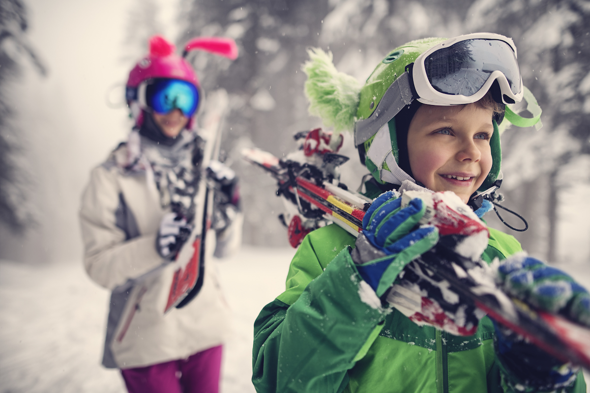 Kids Carrying Skis On A Beautiful Winter Day