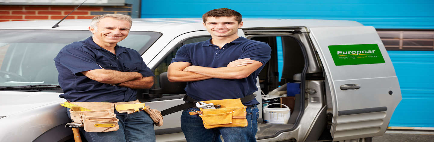 Workers In Family Business Standing Next To Van